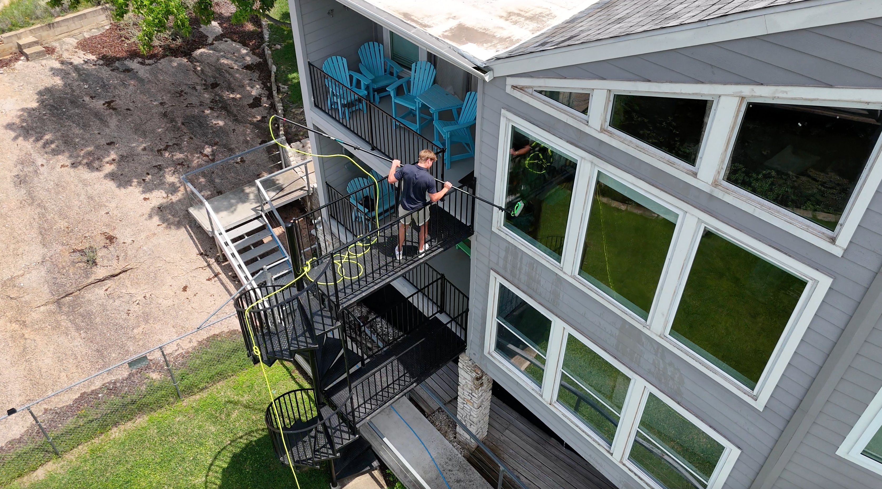 Aerial view of ClearCrew cleaning windows on a Lake LBJ balcony